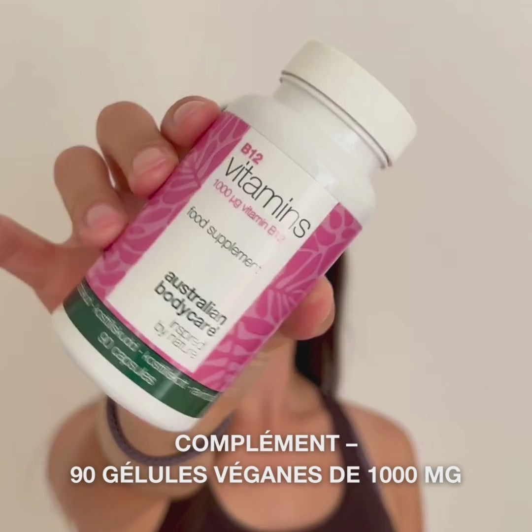 Gros plan d’une main tenant le flacon de complément alimentaire Vitamine B12, ouvrant le couvercle et versant des gélules blanches et lisses – présentation du produit pour un usage quotidien afin de soutenir l’énergie, l’immunité, le système nerveux et réduire la fatigue.