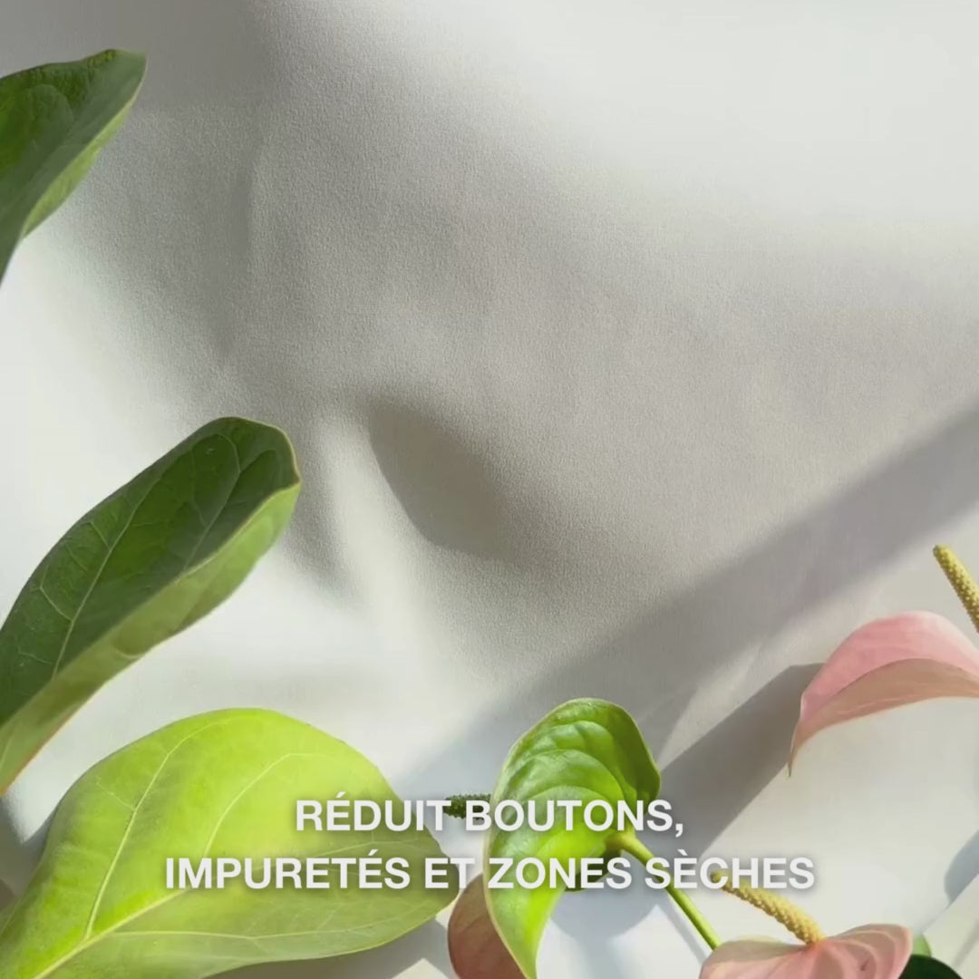 Gros plan sur une main déposant une petite quantité de lotion corporelle légère et crémeuse au salicylique dans la paume, puis la massage sur une peau rugueuse sujette aux imperfections : sa texture lisse et rapidement absorbée exfolie doucement les cellules mortes, hydrate avec de l’acide hyaluronique et lactique et affine la texture avec de l’acide salicylique et niacinamide.